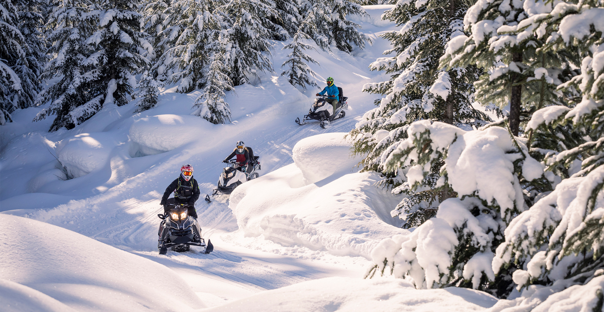 people snowmobiles on a snowy mountain