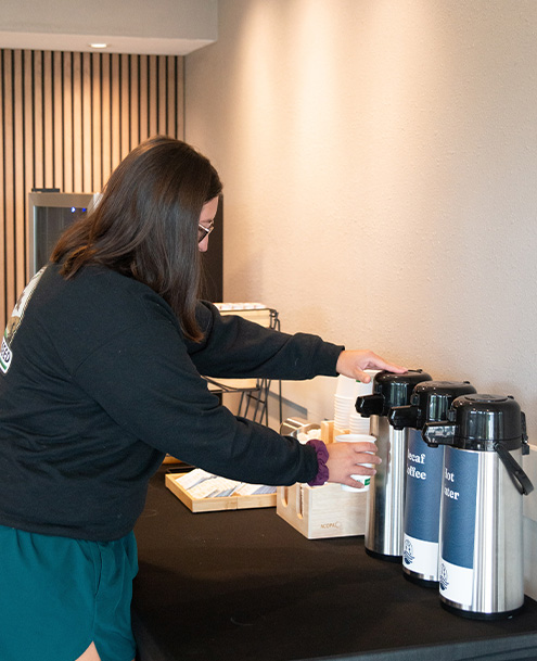 a woman using a coffee maker
