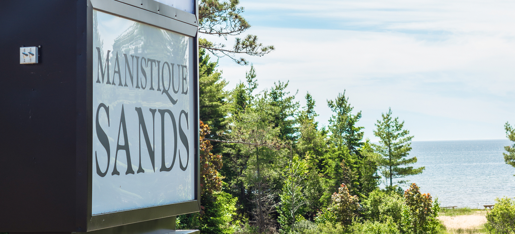 a sign with trees in the background