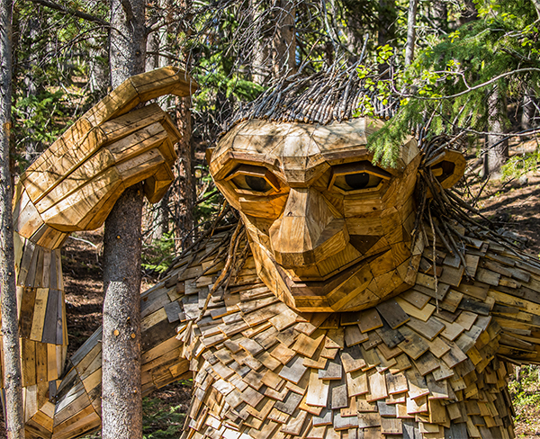 a wooden sculpture of a person holding a tree