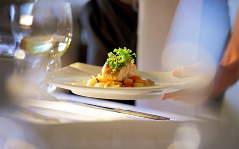 a plate of food and a glass of wine on a table