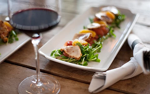 a plate of food and a glass of wine on a table