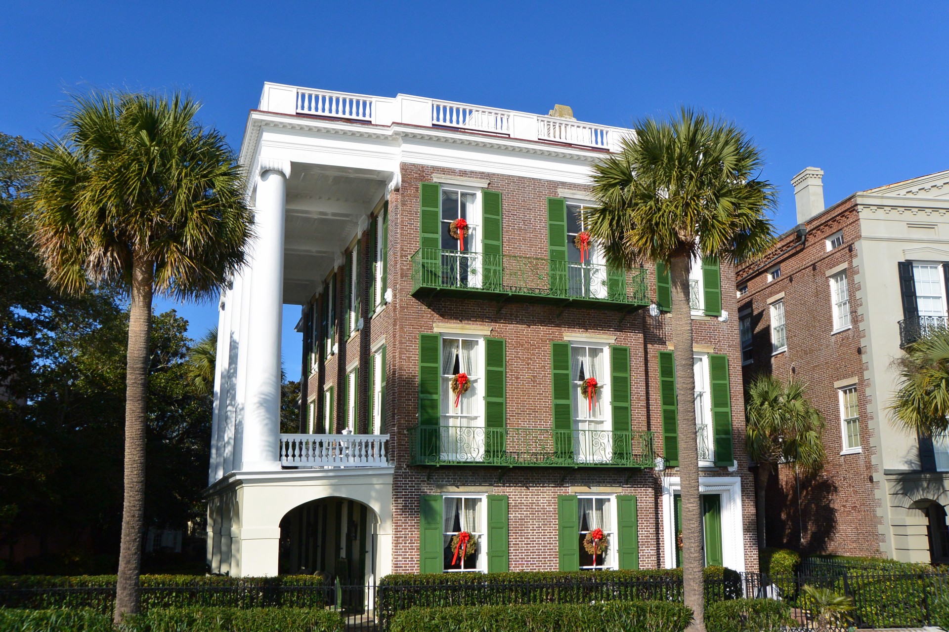 a building with green shutters and red bows
