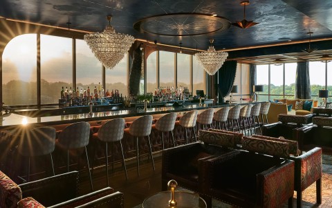 View of a bar with several chairs and 2 chandeliers