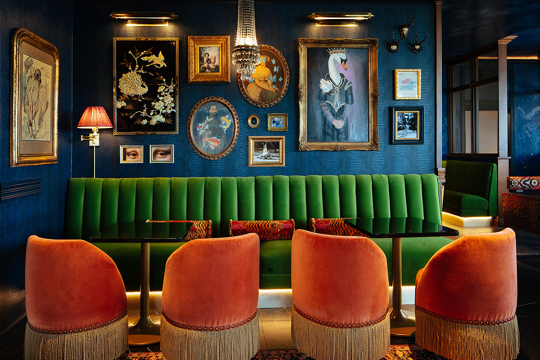 a room with a green couch and orange chairs