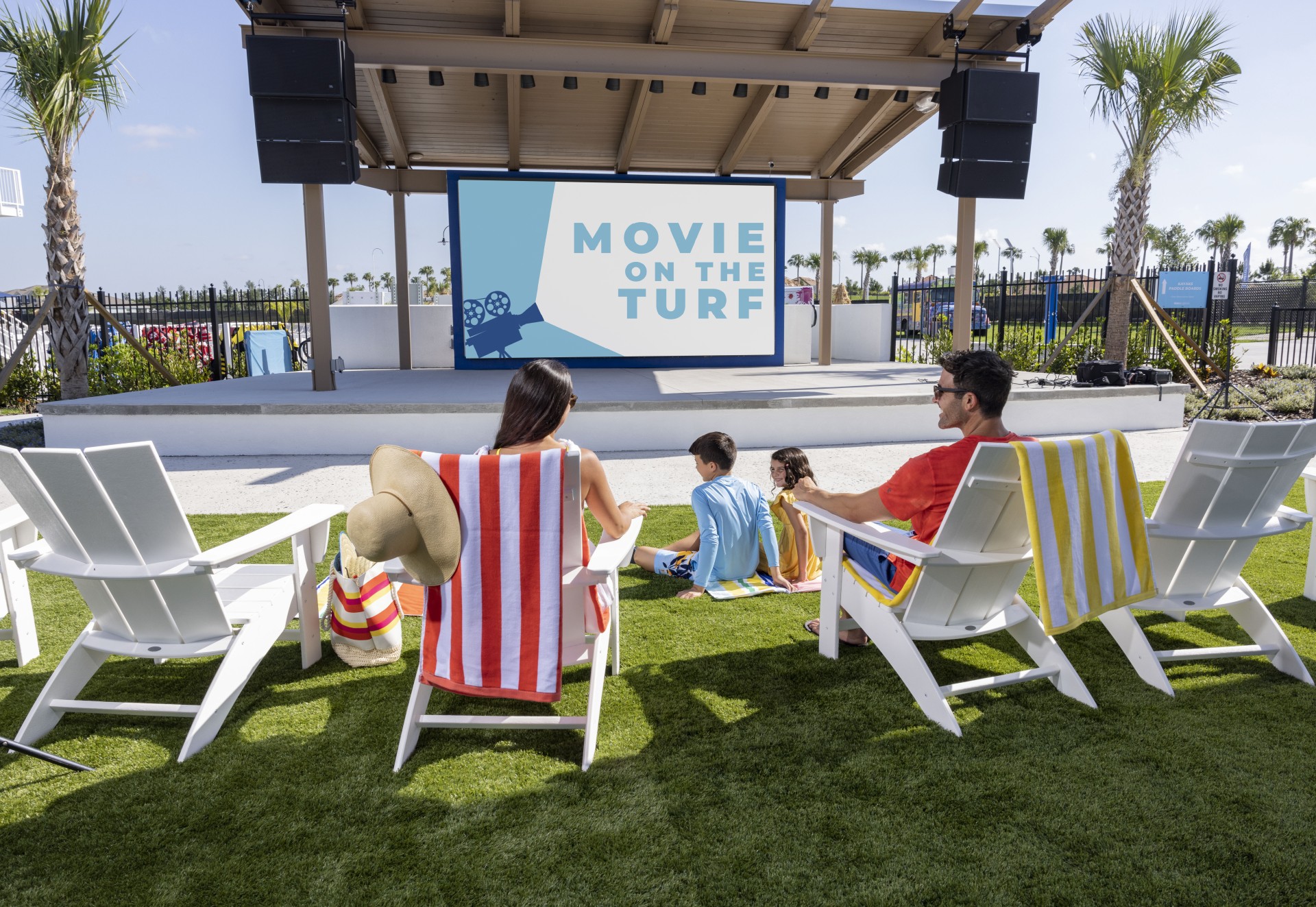 a group of people sitting in chairs on grass