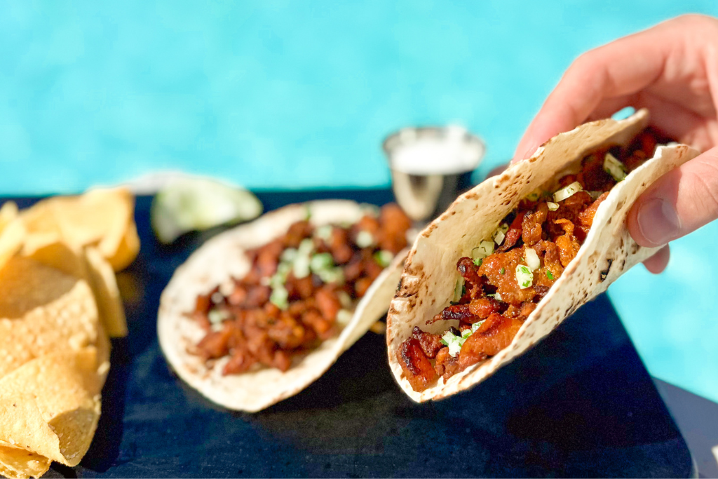 a hand holding a taco