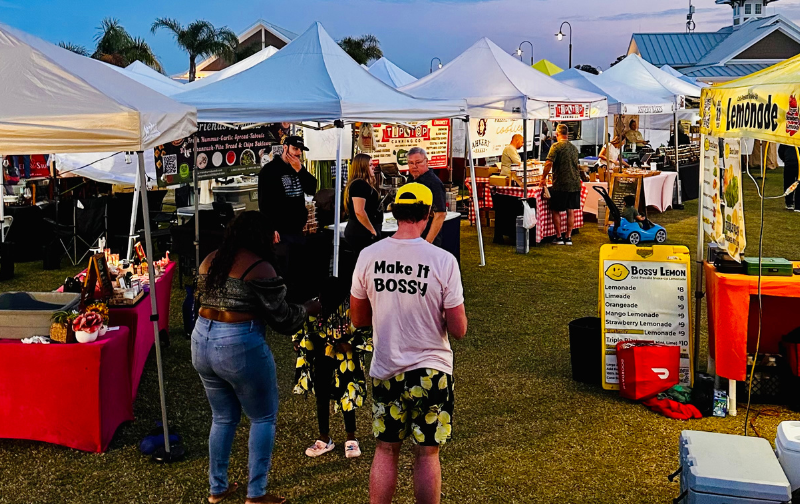 people standing in a field with tents