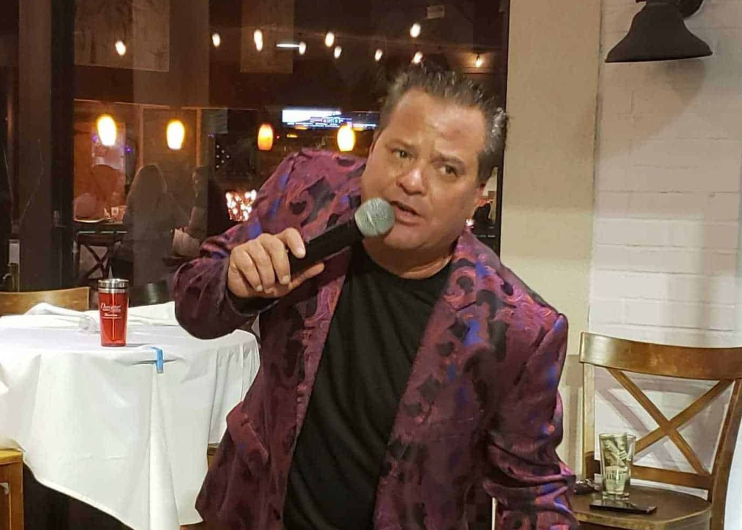 a man in a purple jacket holding a microphone