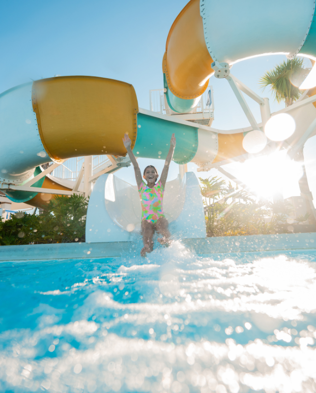 a girl jumping into a water slide