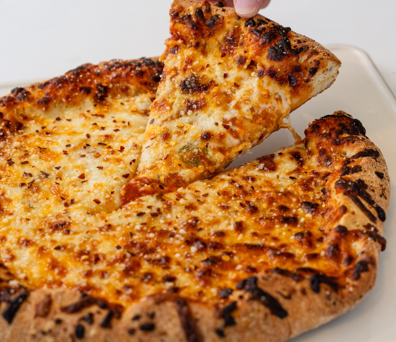 a hand holding a slice of pizza