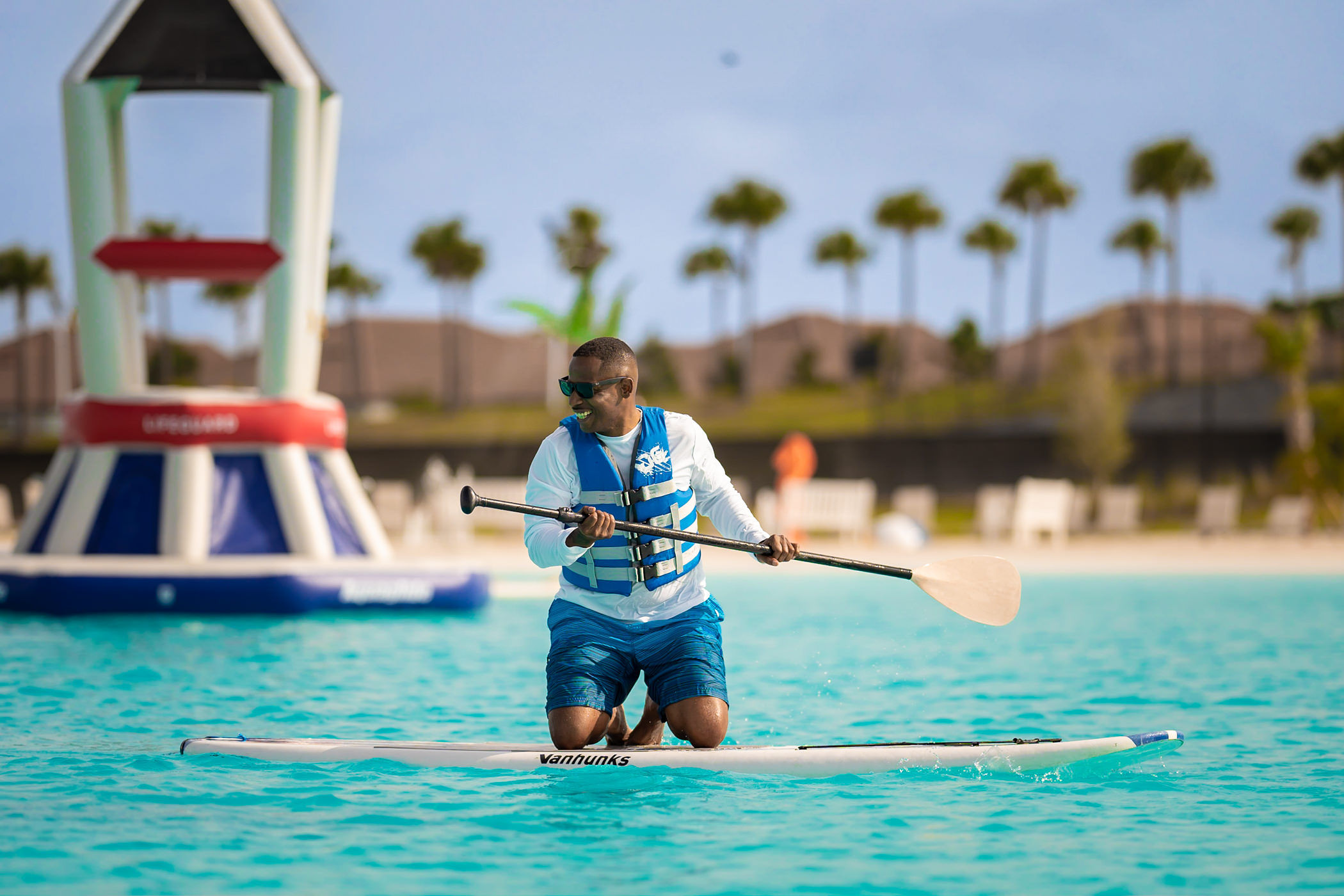 a man on a surfboard with a paddle
