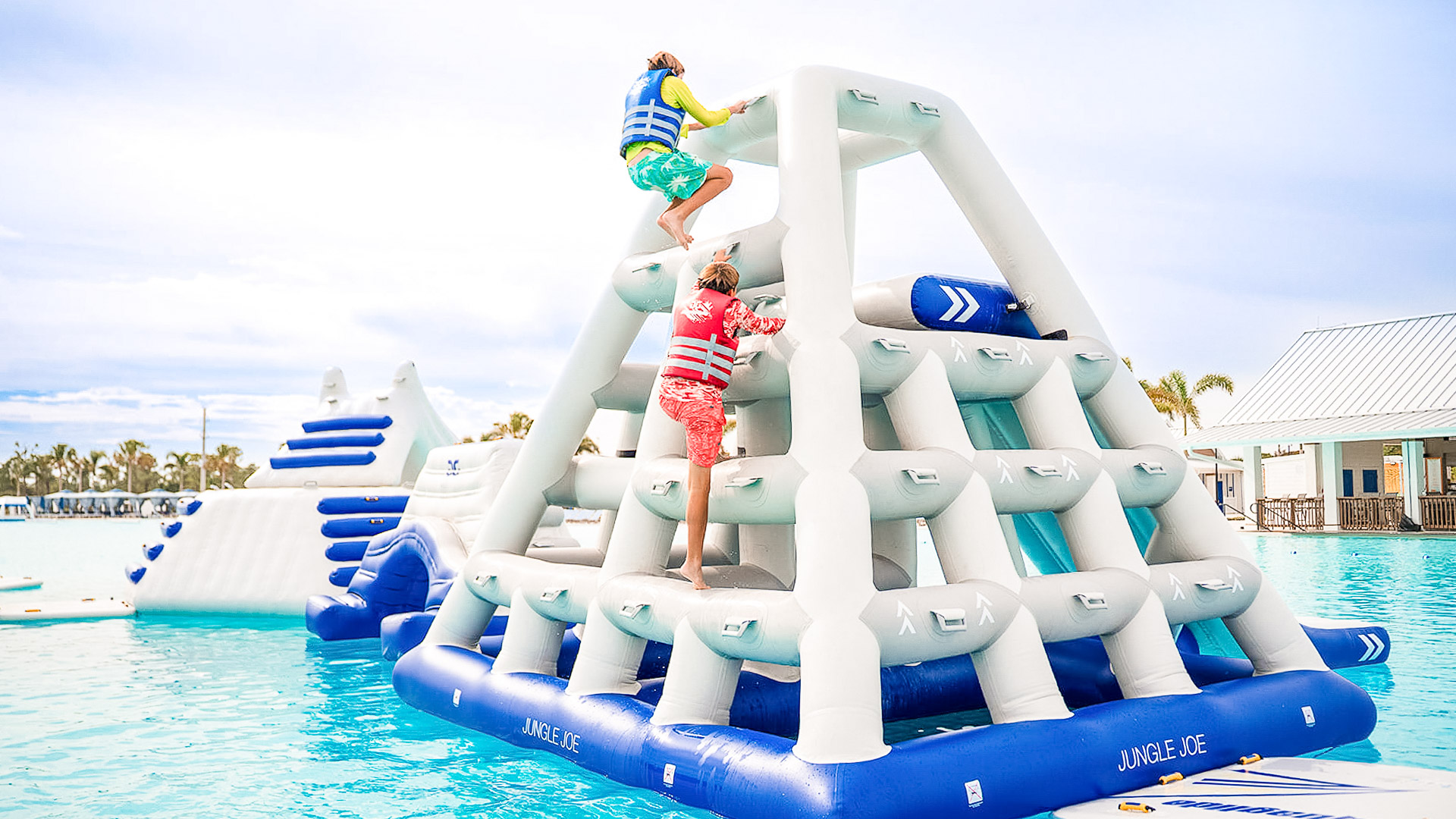 a couple of people climbing up a inflatable structure