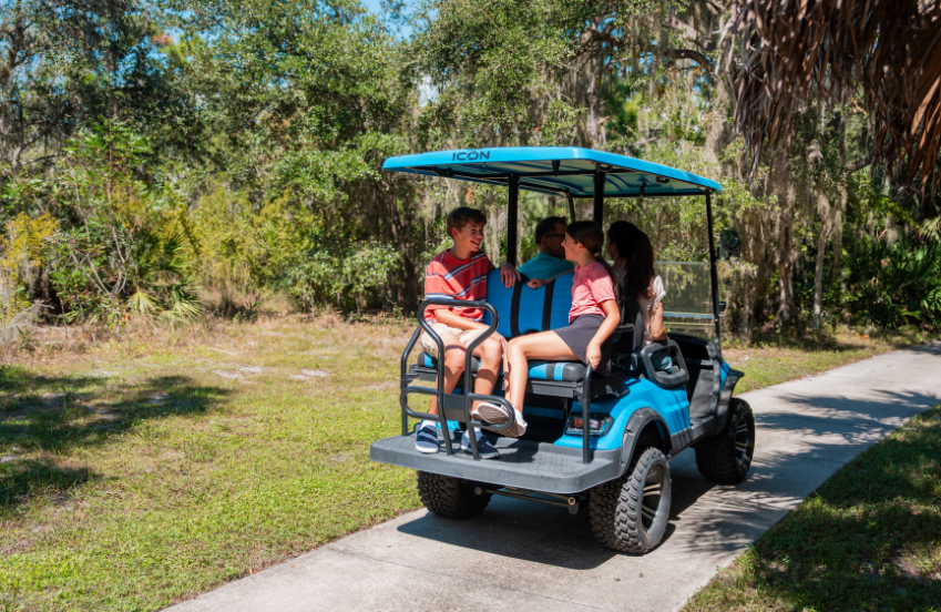 a group of people sitting in a golf cart