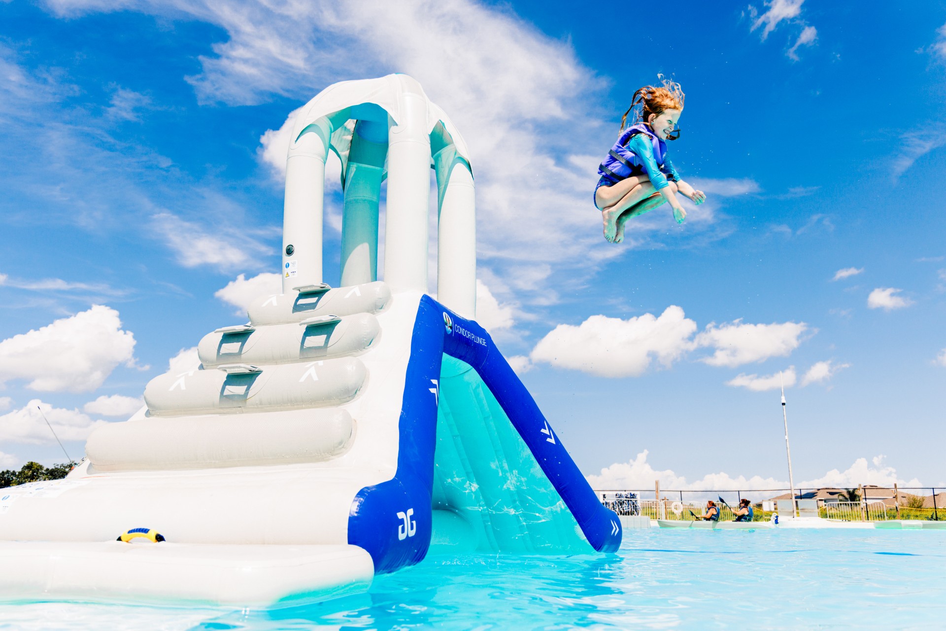 a girl jumping into a water slide