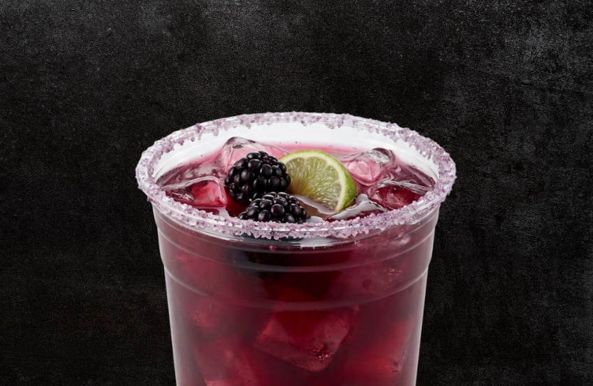 a cup of drink with ice and berries
