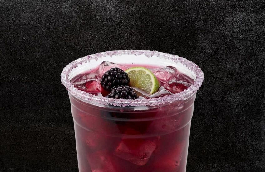 a cup of drink with ice and berries