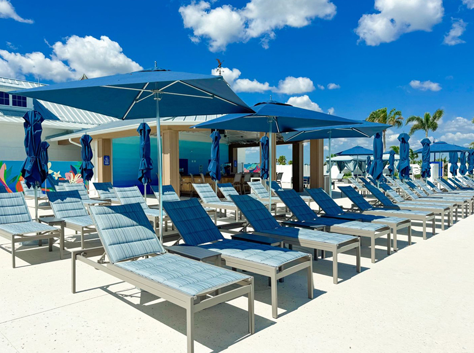 a group of lounge chairs and umbrellas outside