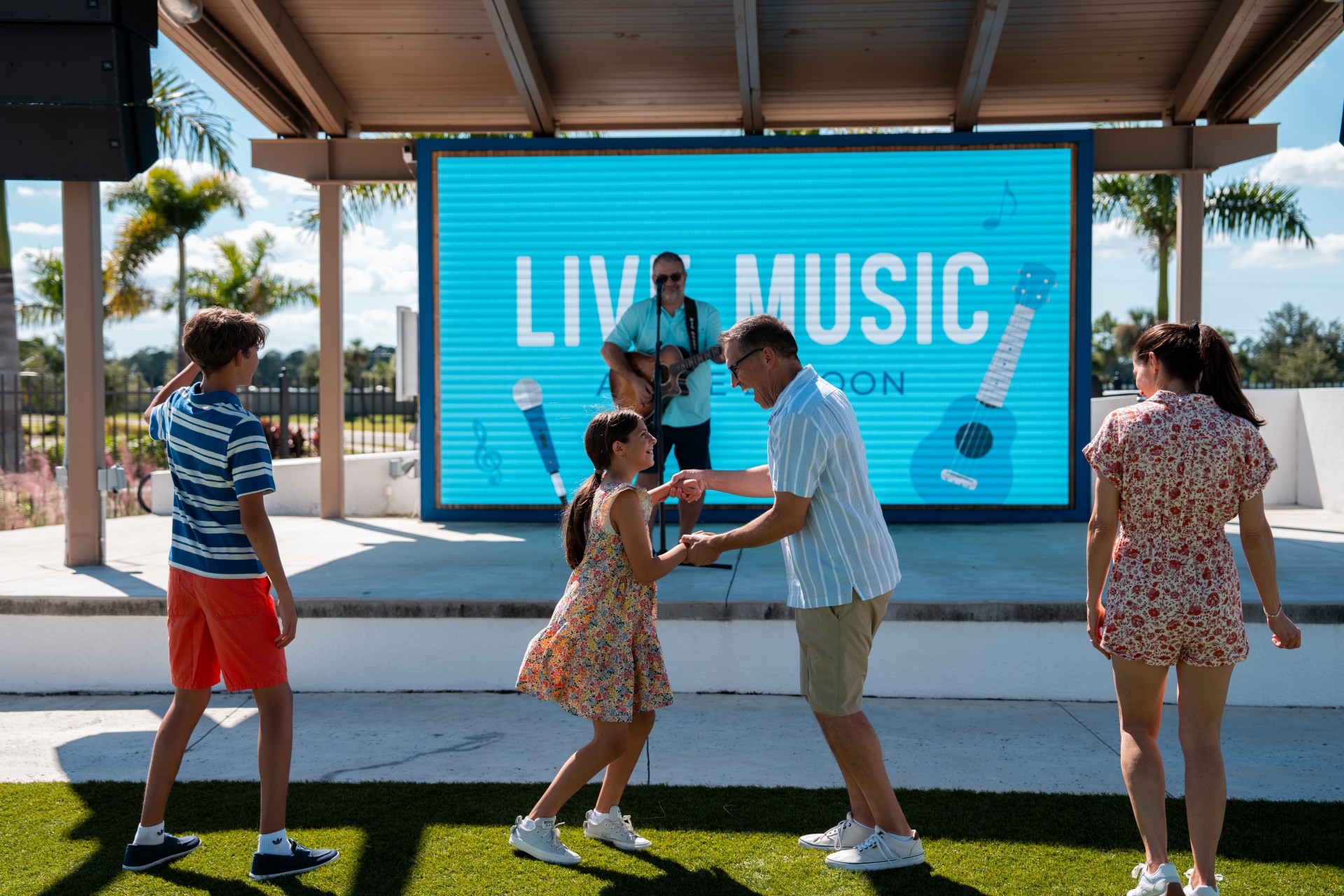 a group of people standing in a grass field