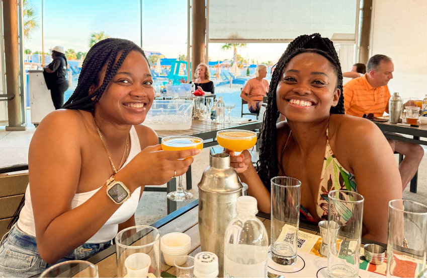 two women sitting at a table with drinks