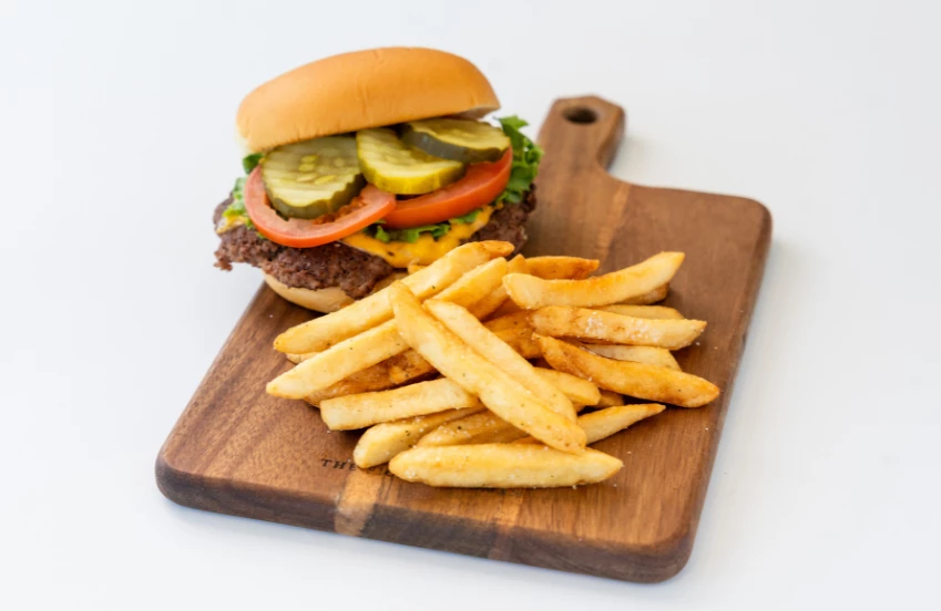 a burger and fries on a cutting board