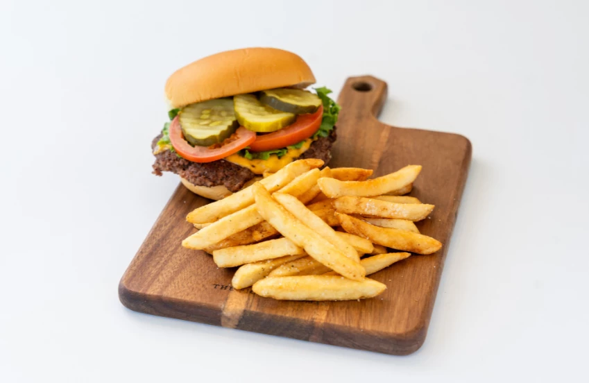 a burger and fries on a cutting board
