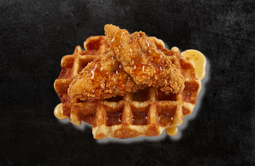 a chicken and waffle with sauce