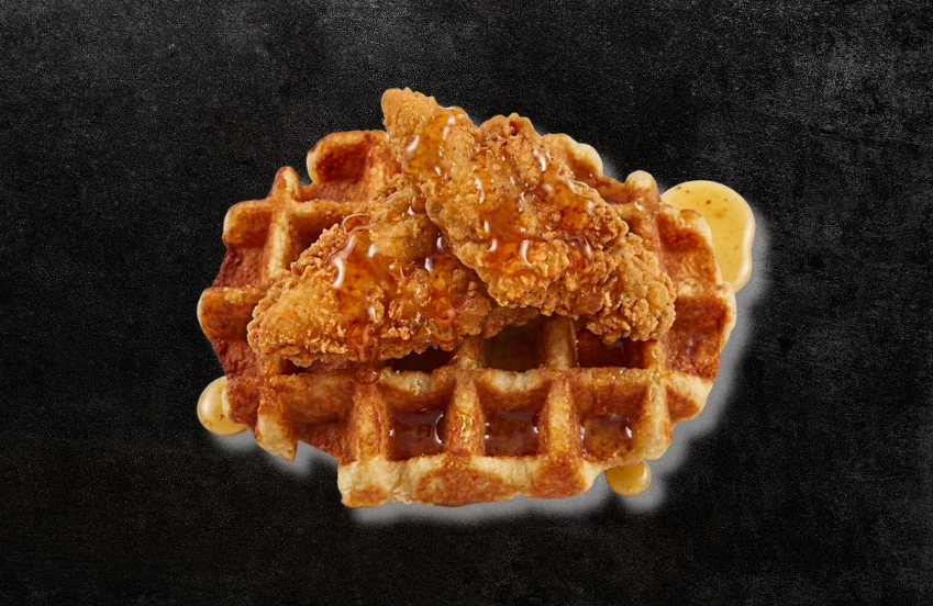 a chicken and waffle with sauce