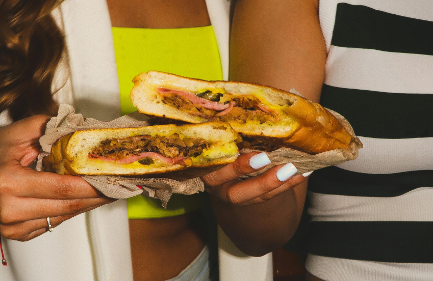 a person holding a sandwich