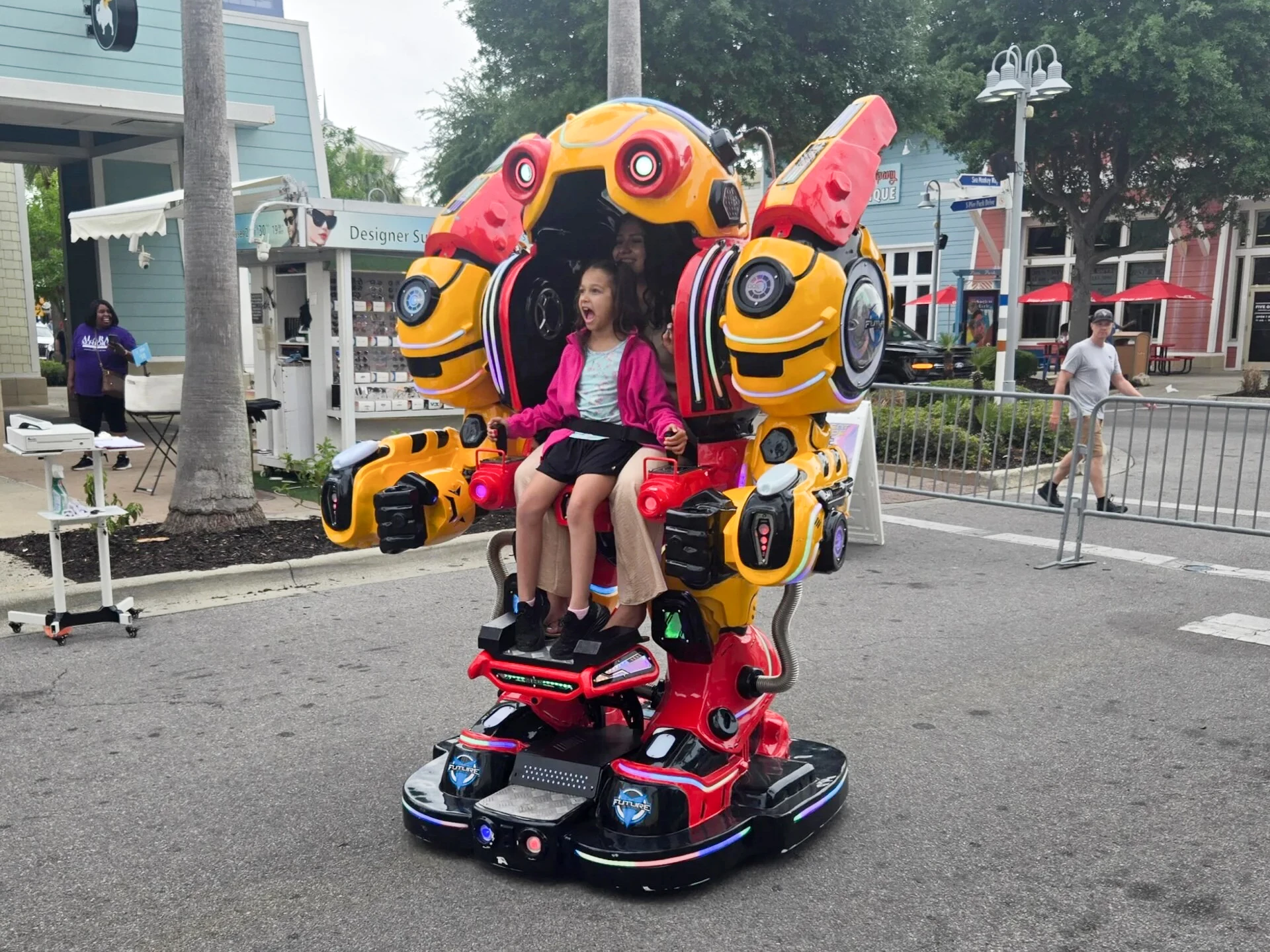a girl sitting in a robot ride