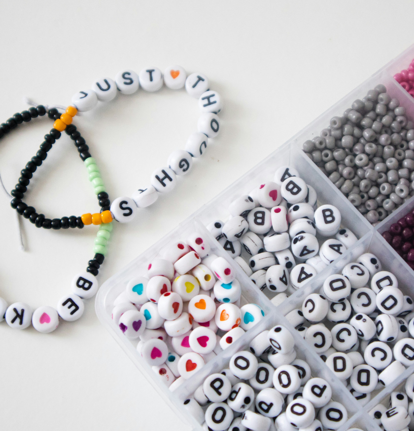 a plastic container with beads and a bracelet