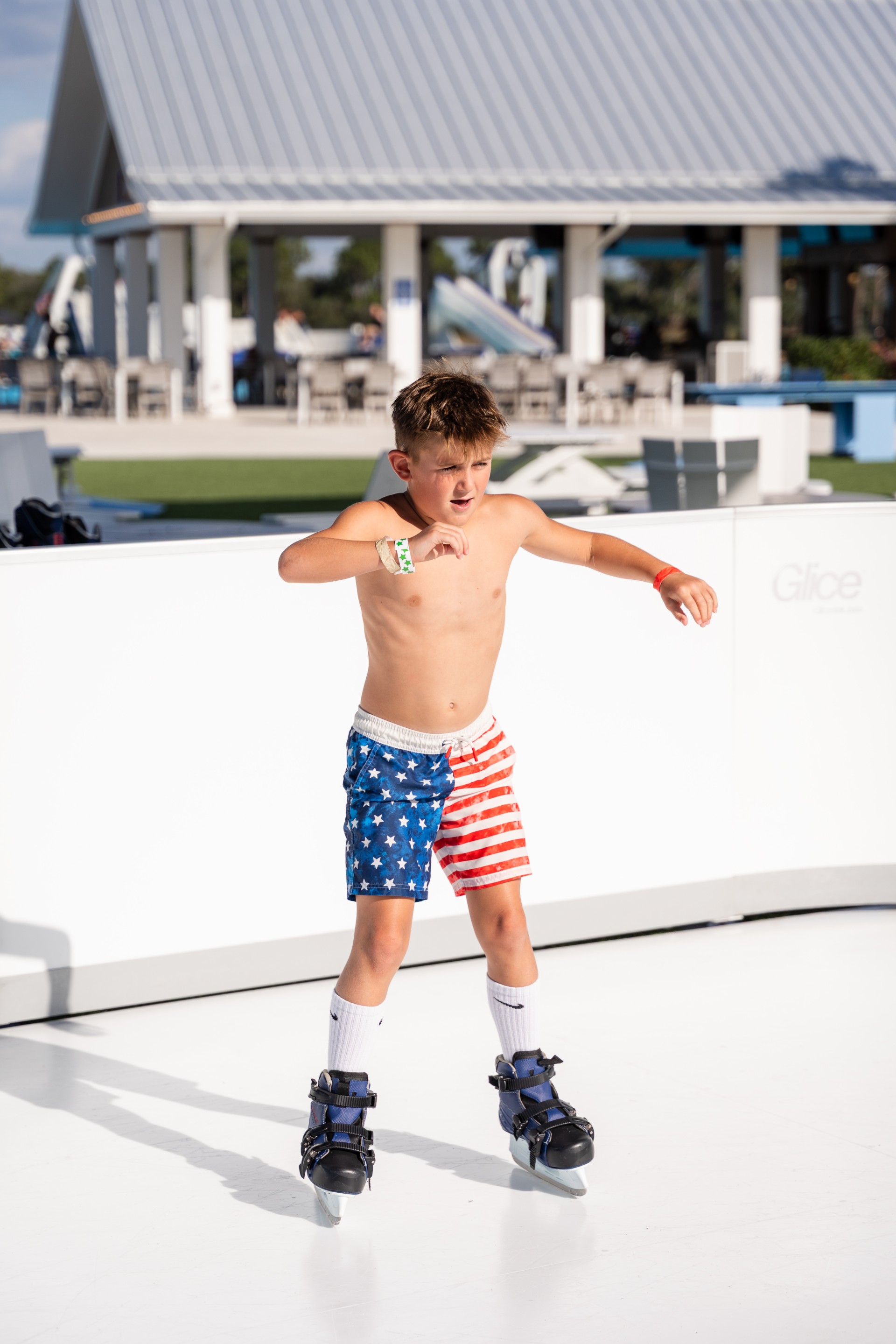 a boy wearing blue and red shorts and roller skates