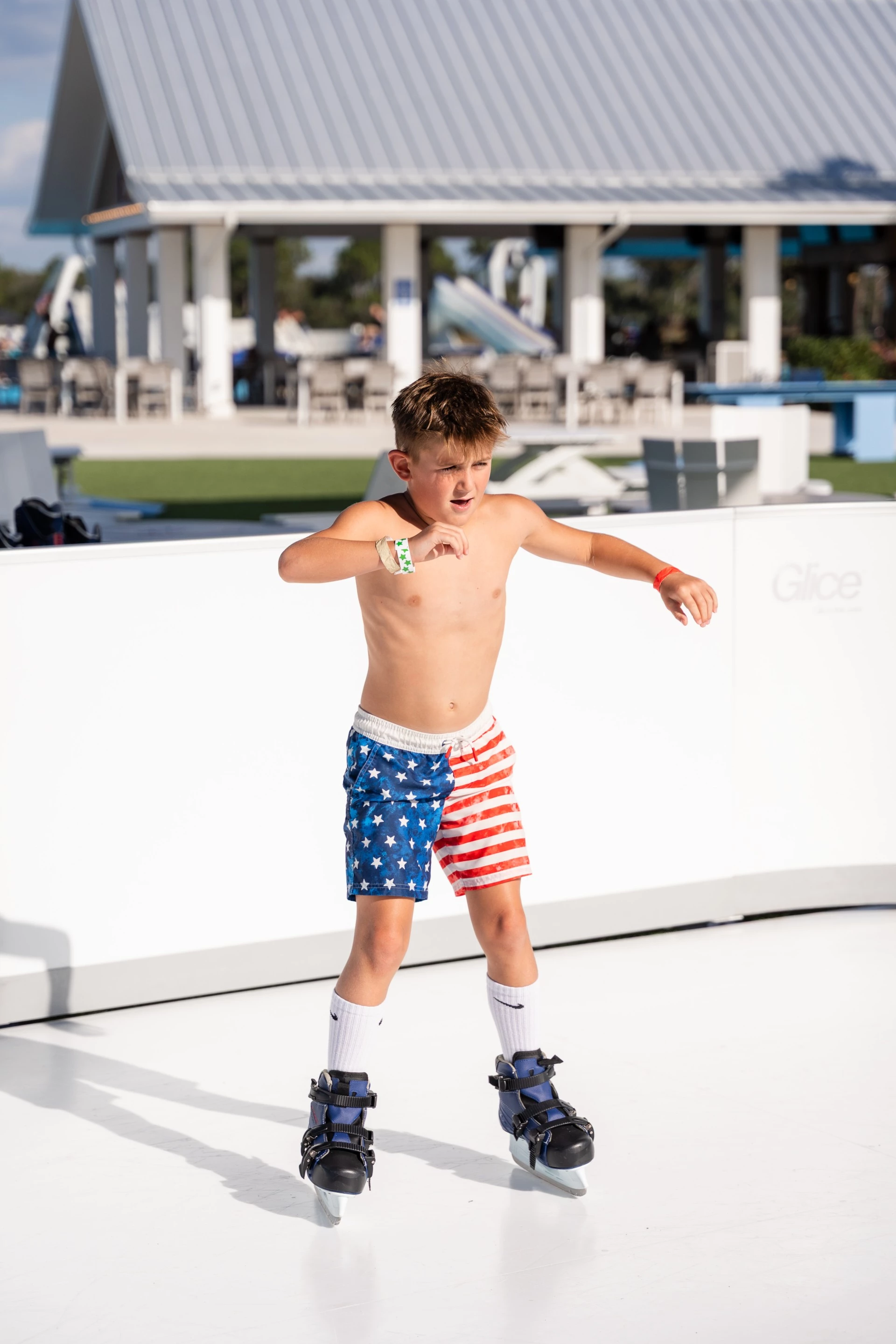 a boy wearing blue and red shorts and roller skates