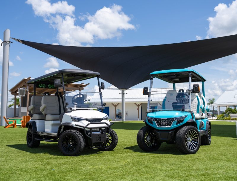 two golf carts parked on a green field