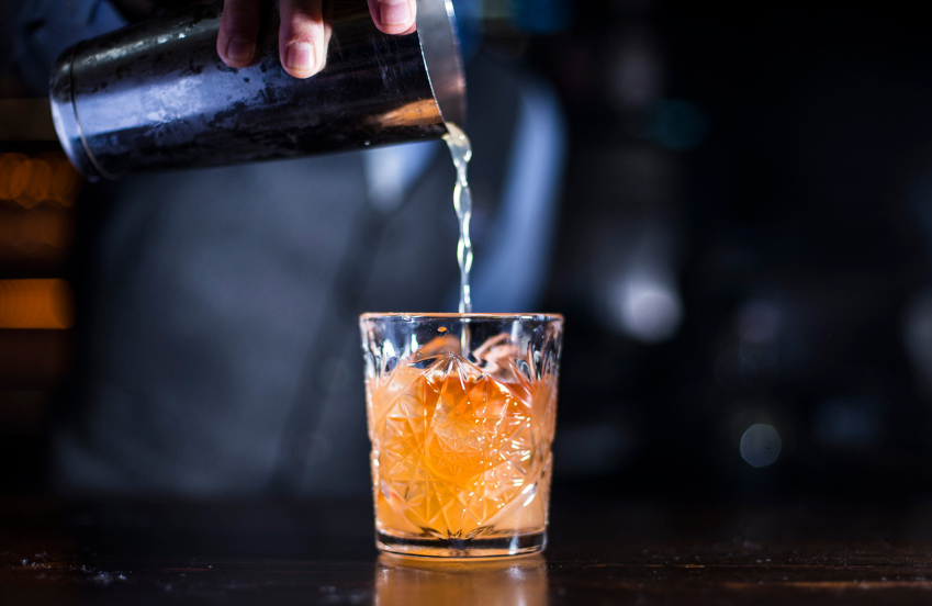a person pouring liquid into a glass