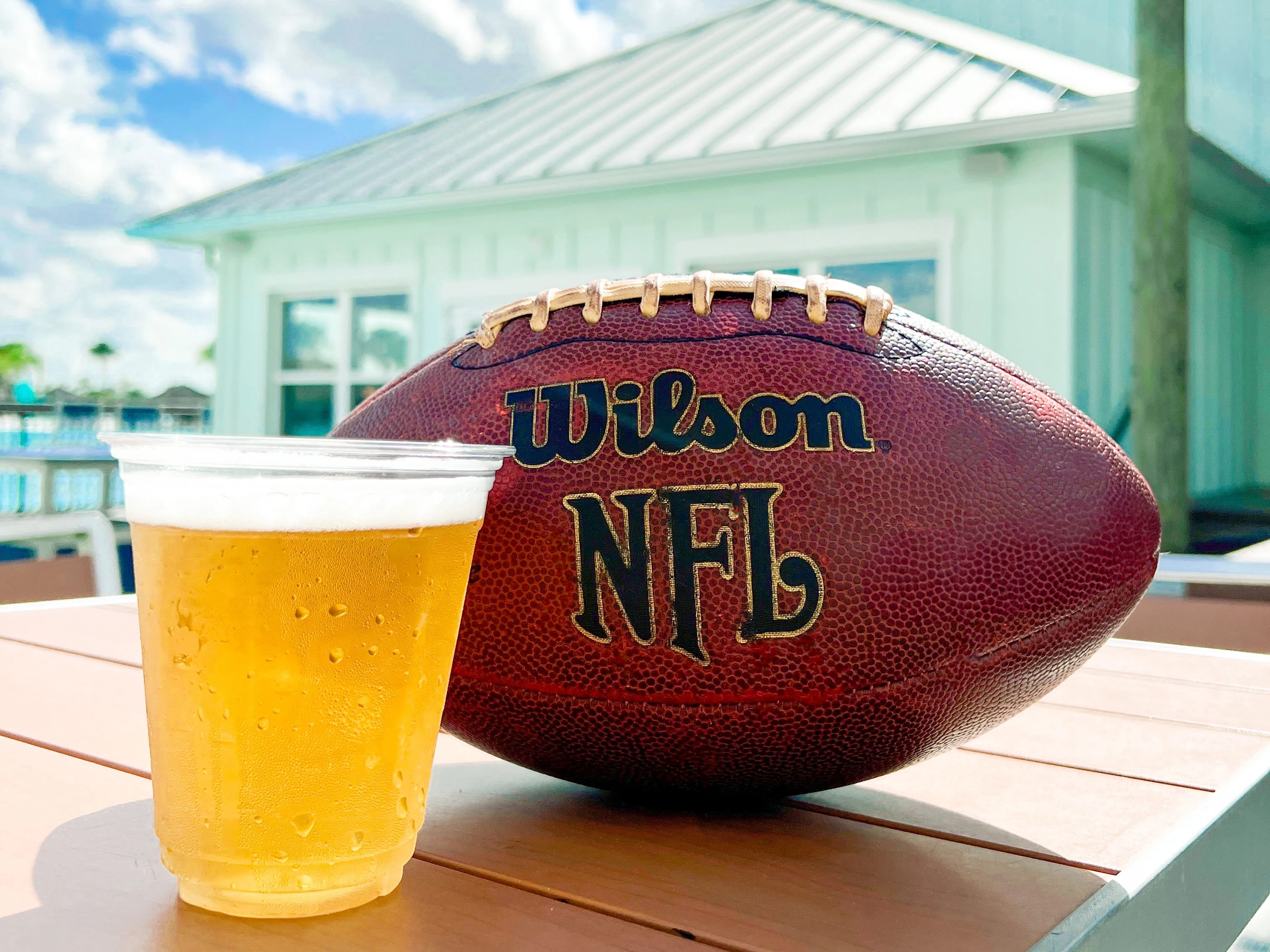 a football and a glass of beer on a table