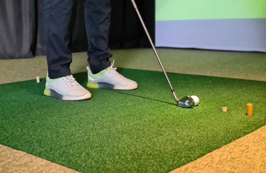 a person playing golf on a green carpet