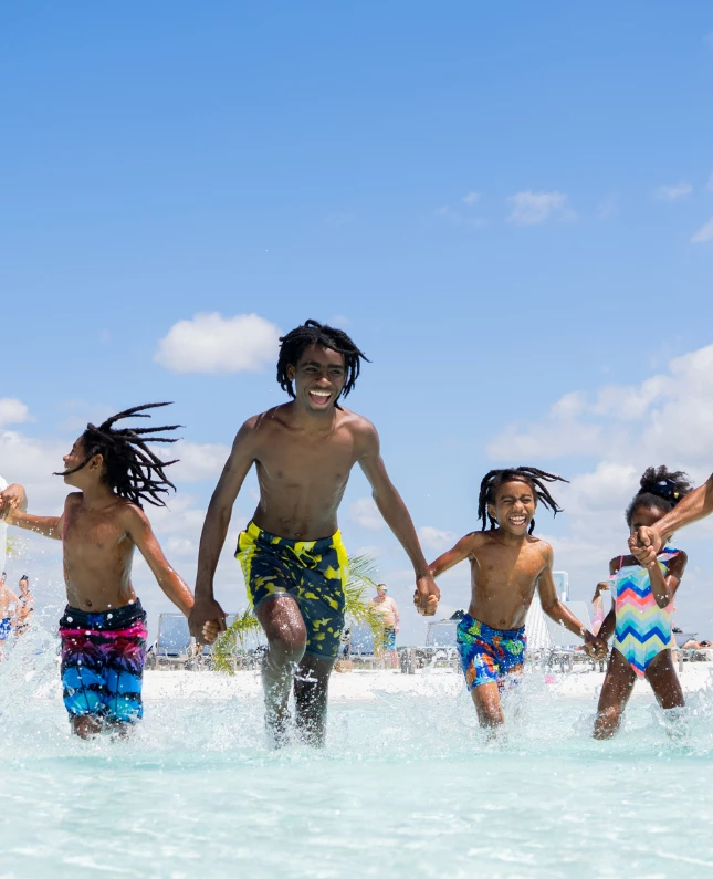 a group of people running in water