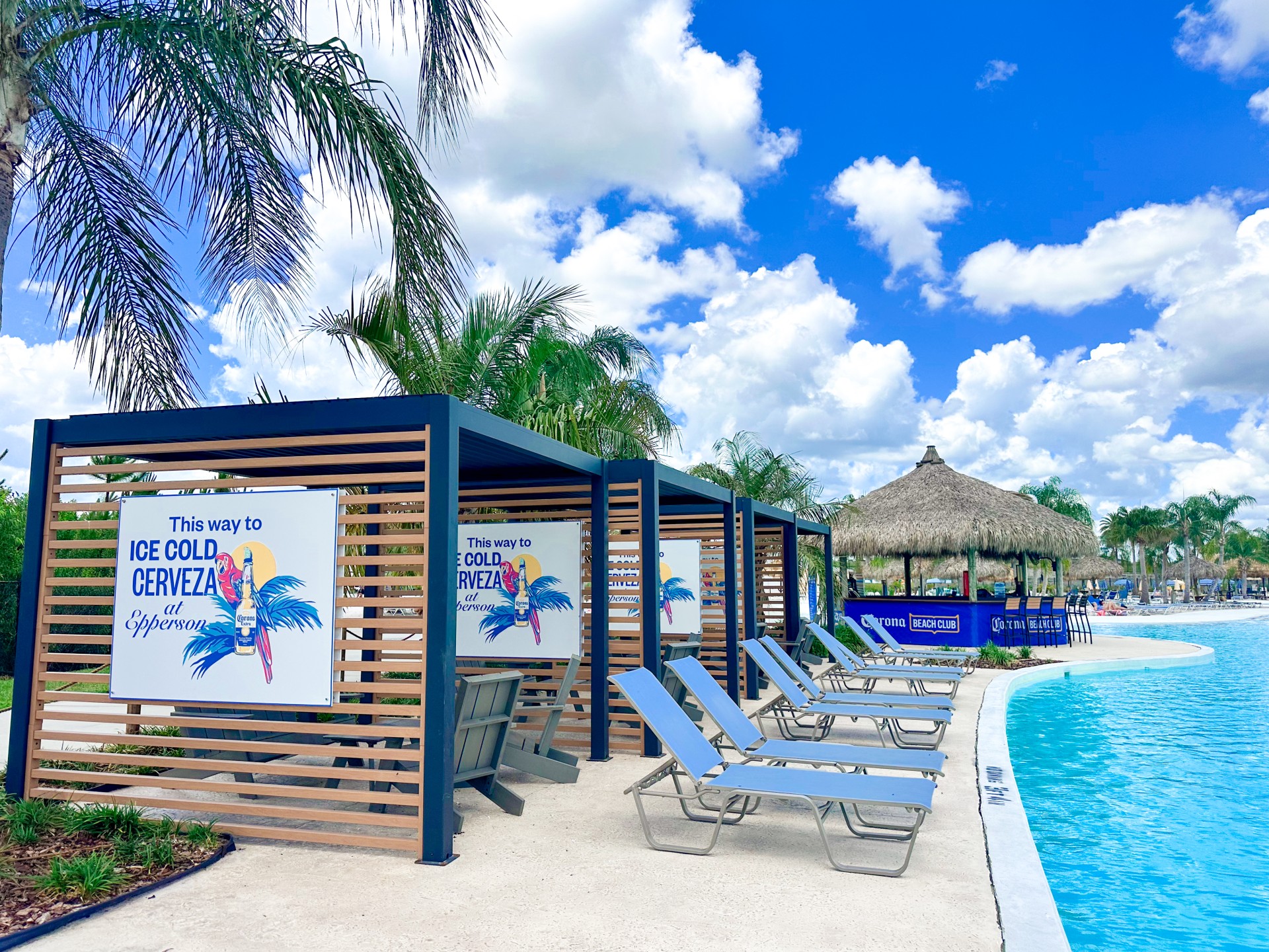 a pool with lounge chairs and a hut