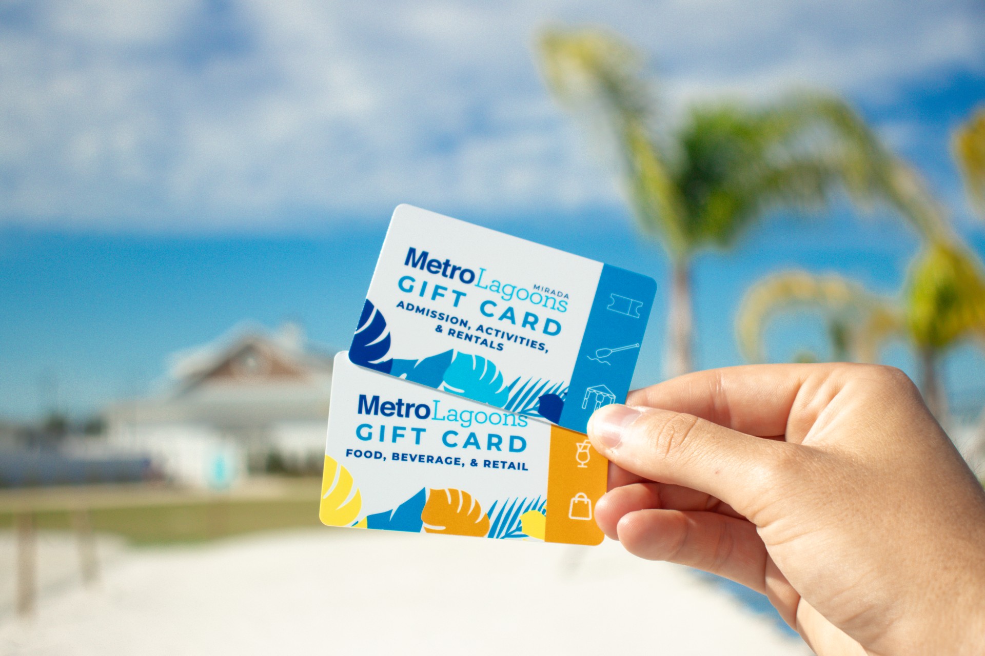 a hand holding up two gift cards