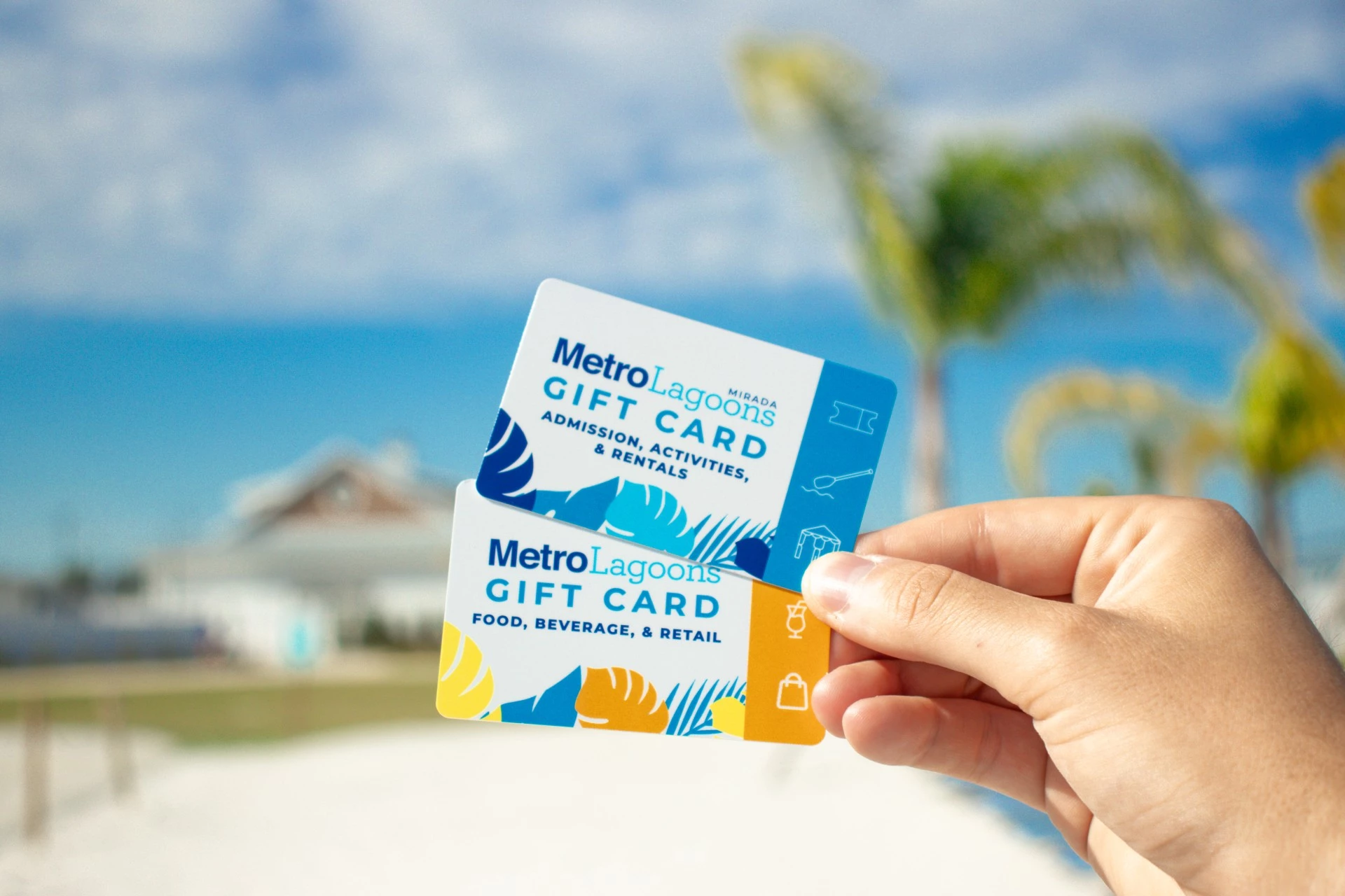 a hand holding up two gift cards