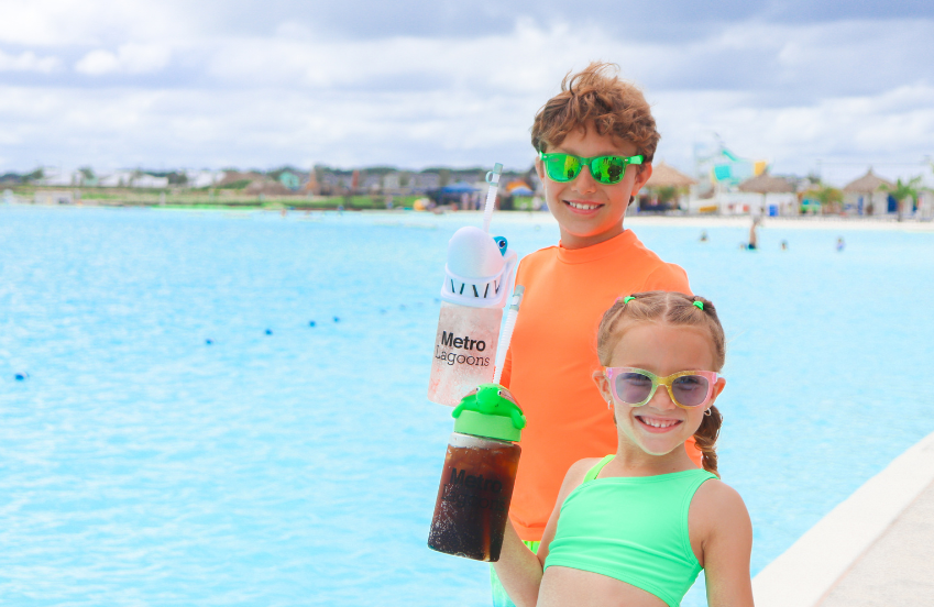 a boy and girl in swimsuits holding drinks