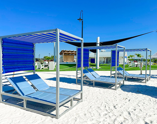 a group of blue lounge chairs on a beach