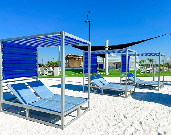 a group of blue lounge chairs on a beach