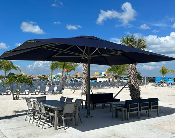 a table and chairs under a umbrella on a beach