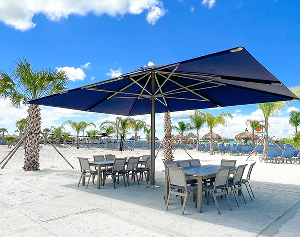 a table and chairs under a umbrella on a beach