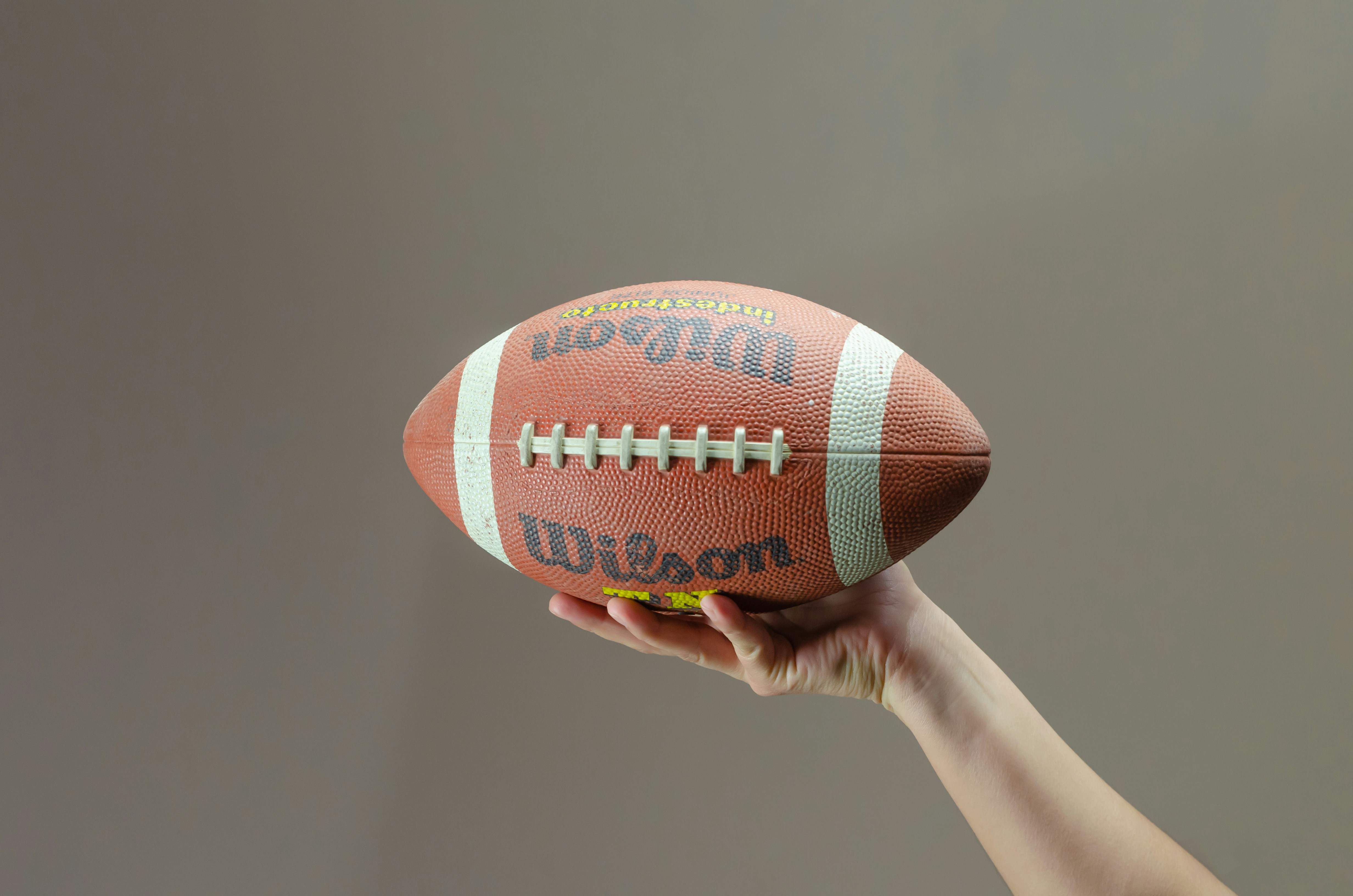 a hand holding a football