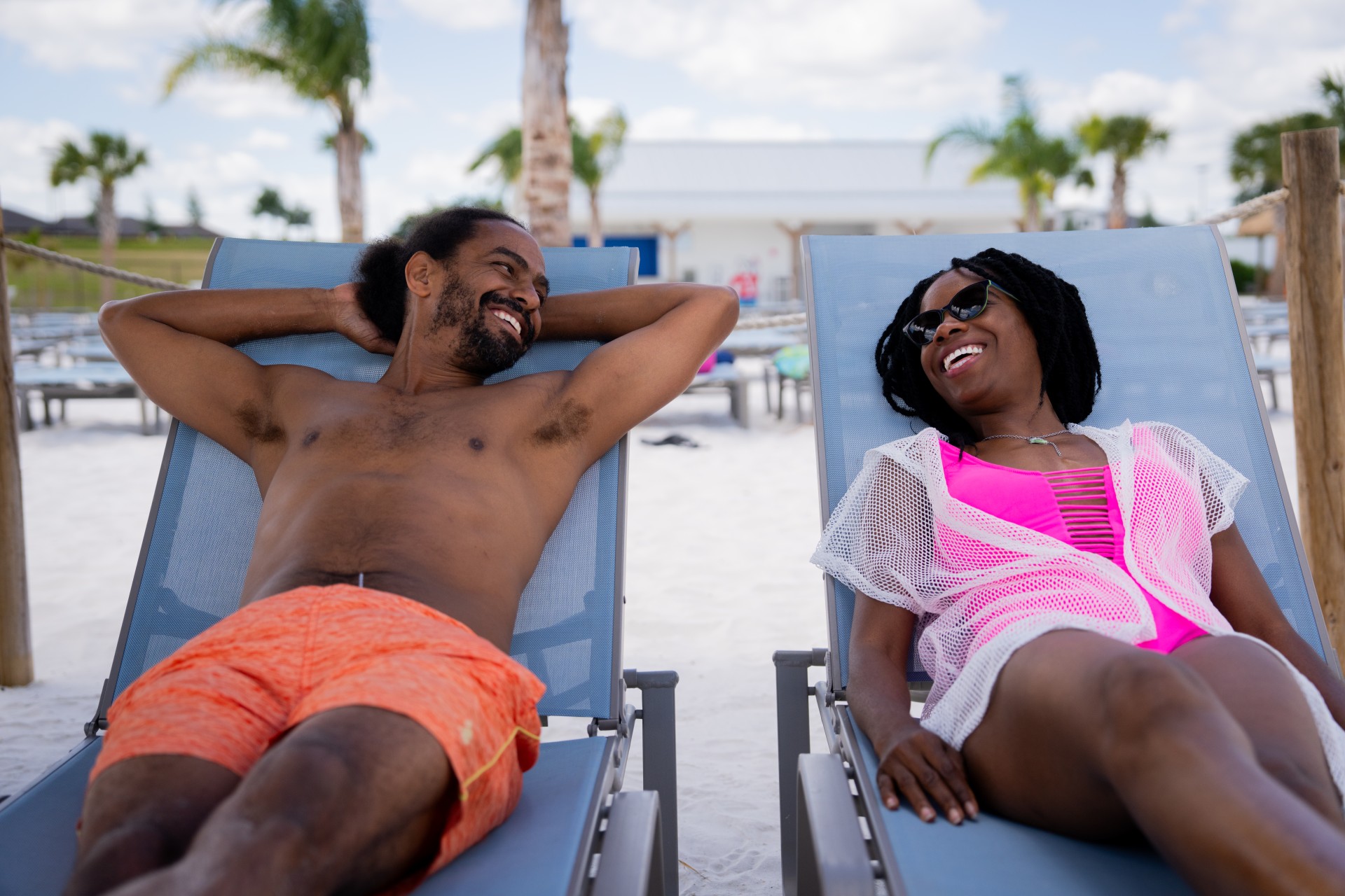 a man and woman lying on lounge chairs