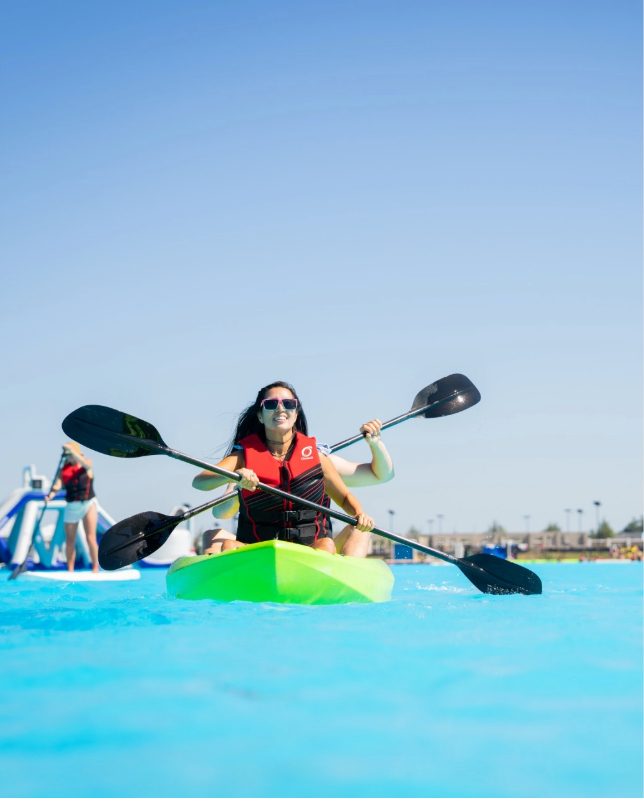 a woman in a kayak with paddles