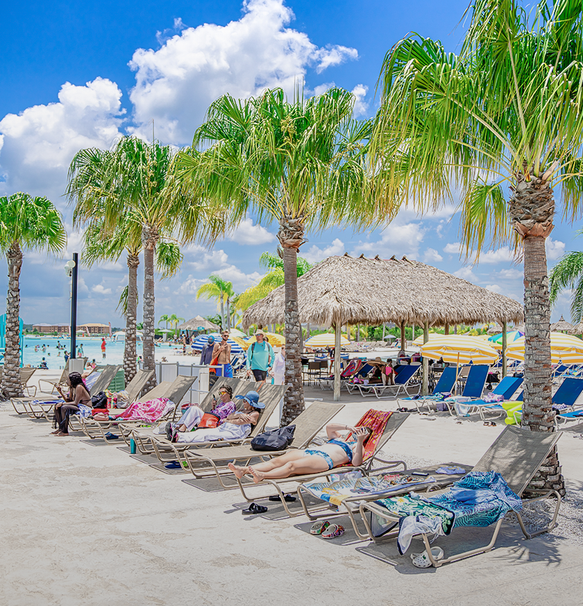 a group of people sitting in lounge chairs on a beach
